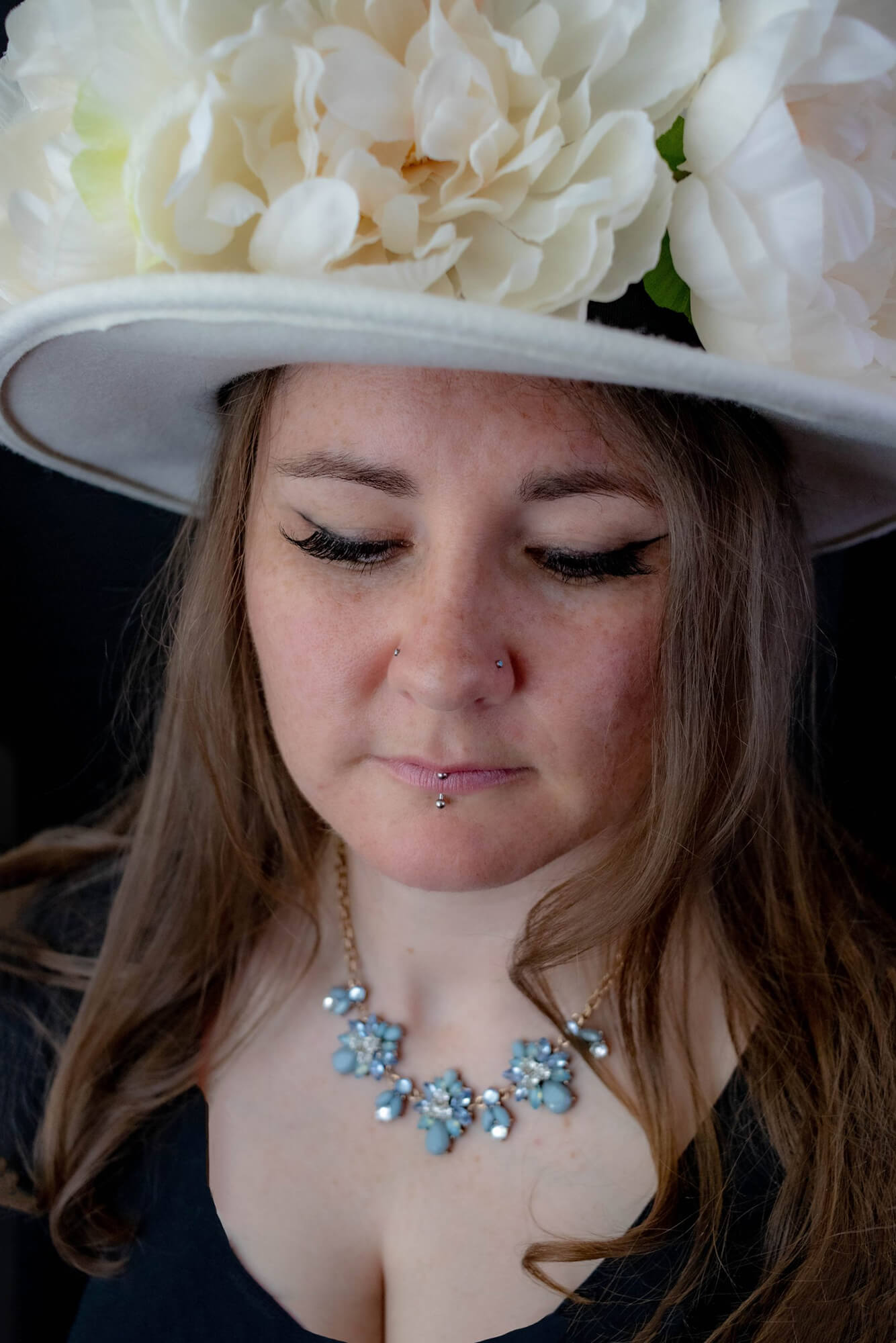 Young woman wearing a large hat with flowers, My Fair Lady style